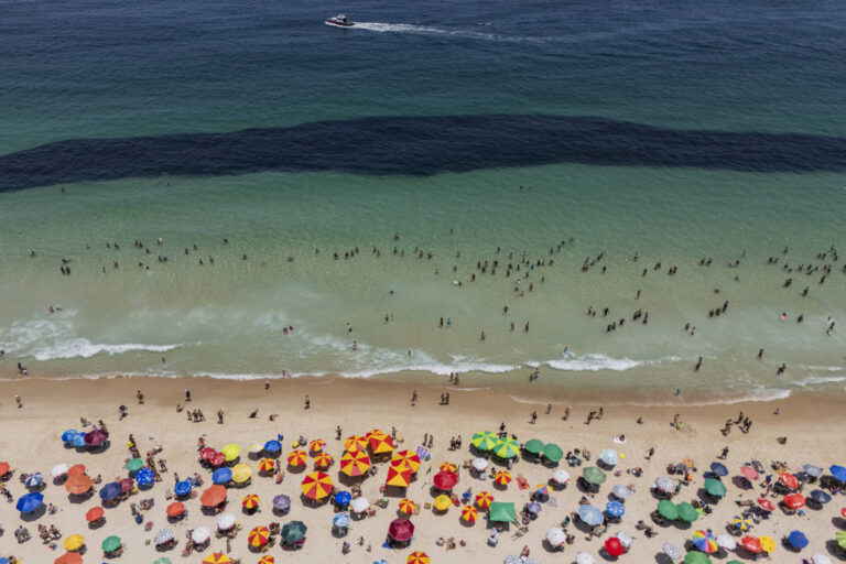 Mancha escura na praia de Copacabana causada por cardume de peixes