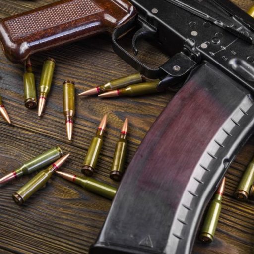 Fuzil Ak-47 com balas em cima de mesa  • Getty Images/Anton Petrus